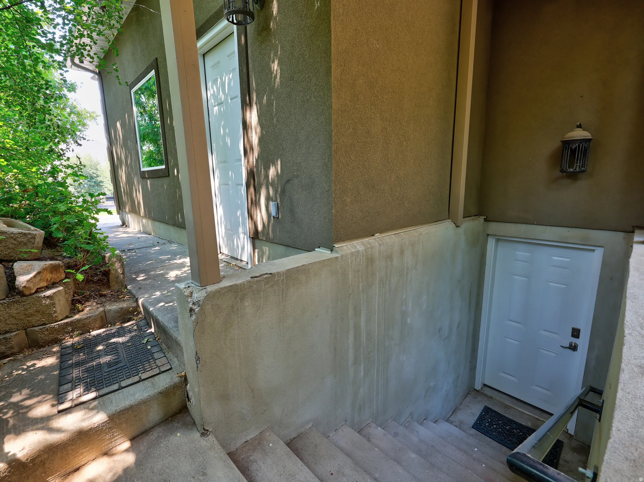 Stucco exterior with multiple white entry doors and an exterior window