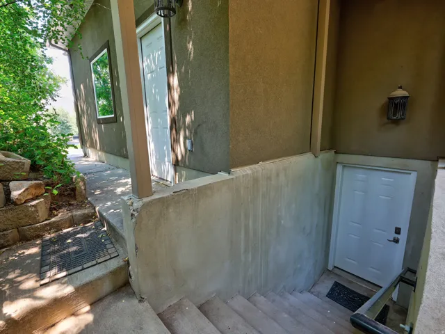 Stucco exterior with multiple white entry doors and an exterior window