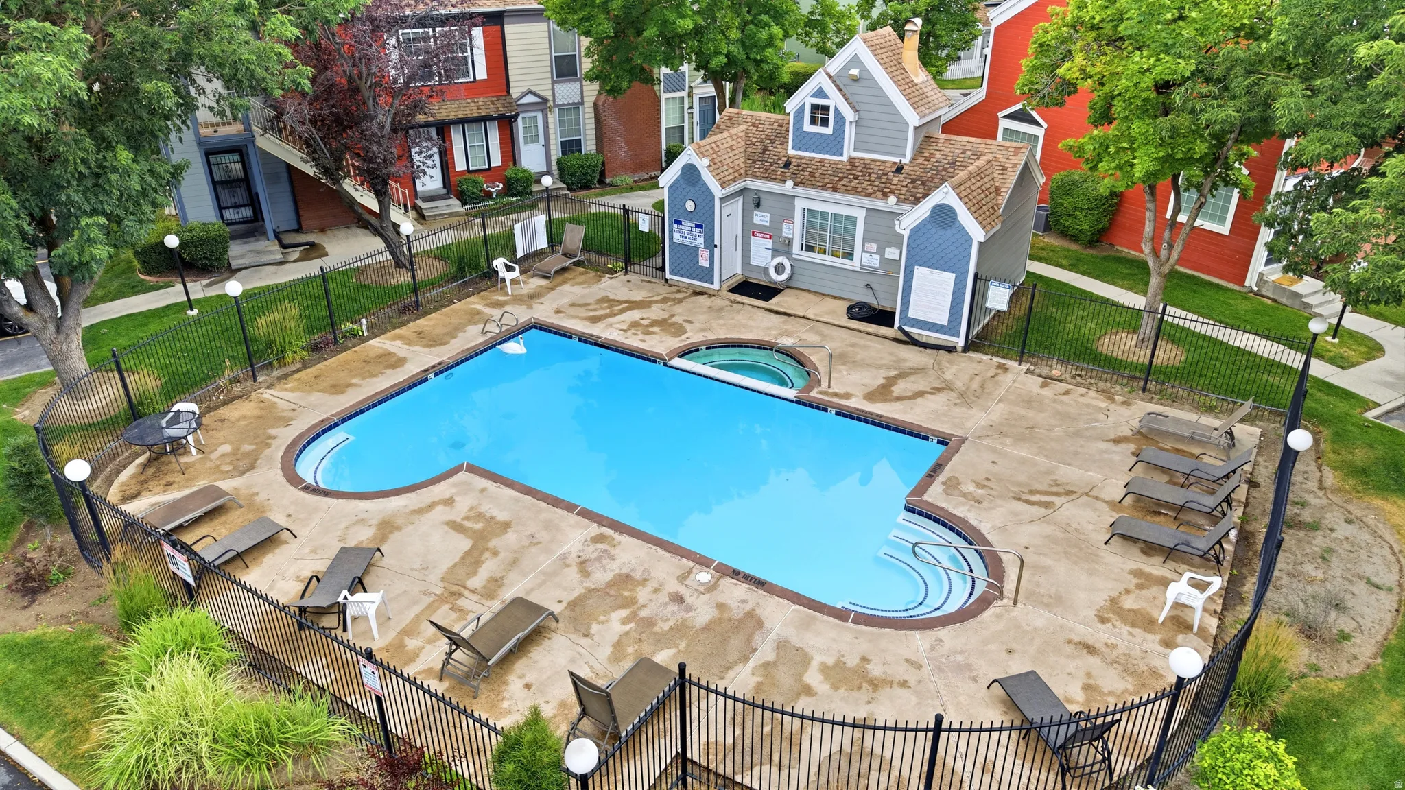 Community Outdoor swimming pool with integrated spa and concrete surround