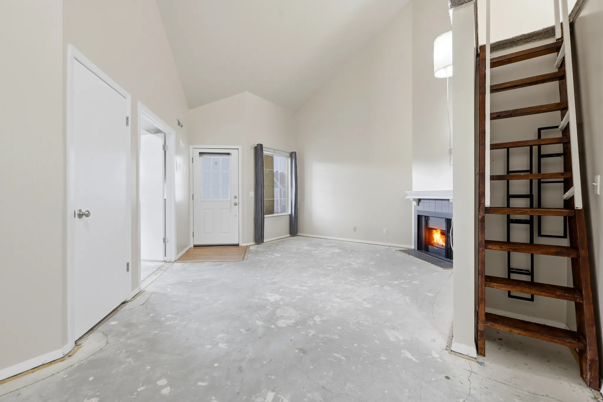 A view back toward the front door. Coat closet and doors into the front bedroom. Ladder up to the loft, pictured.