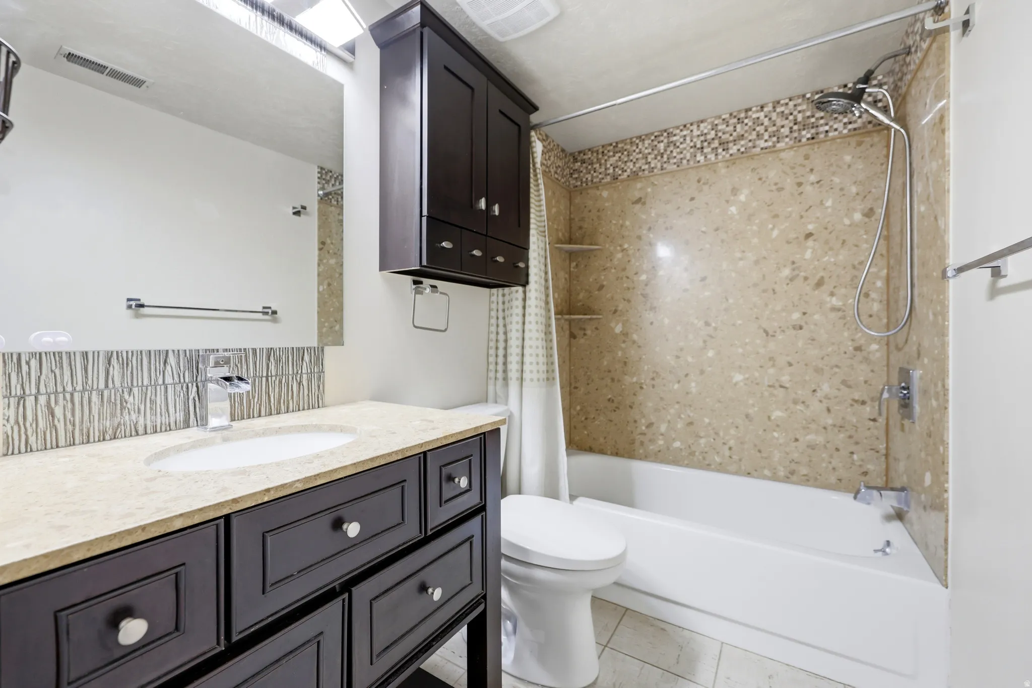 Bathroom featuring a dark wood vanity with a light countertop, an oval undermount sink, and a chrome faucet