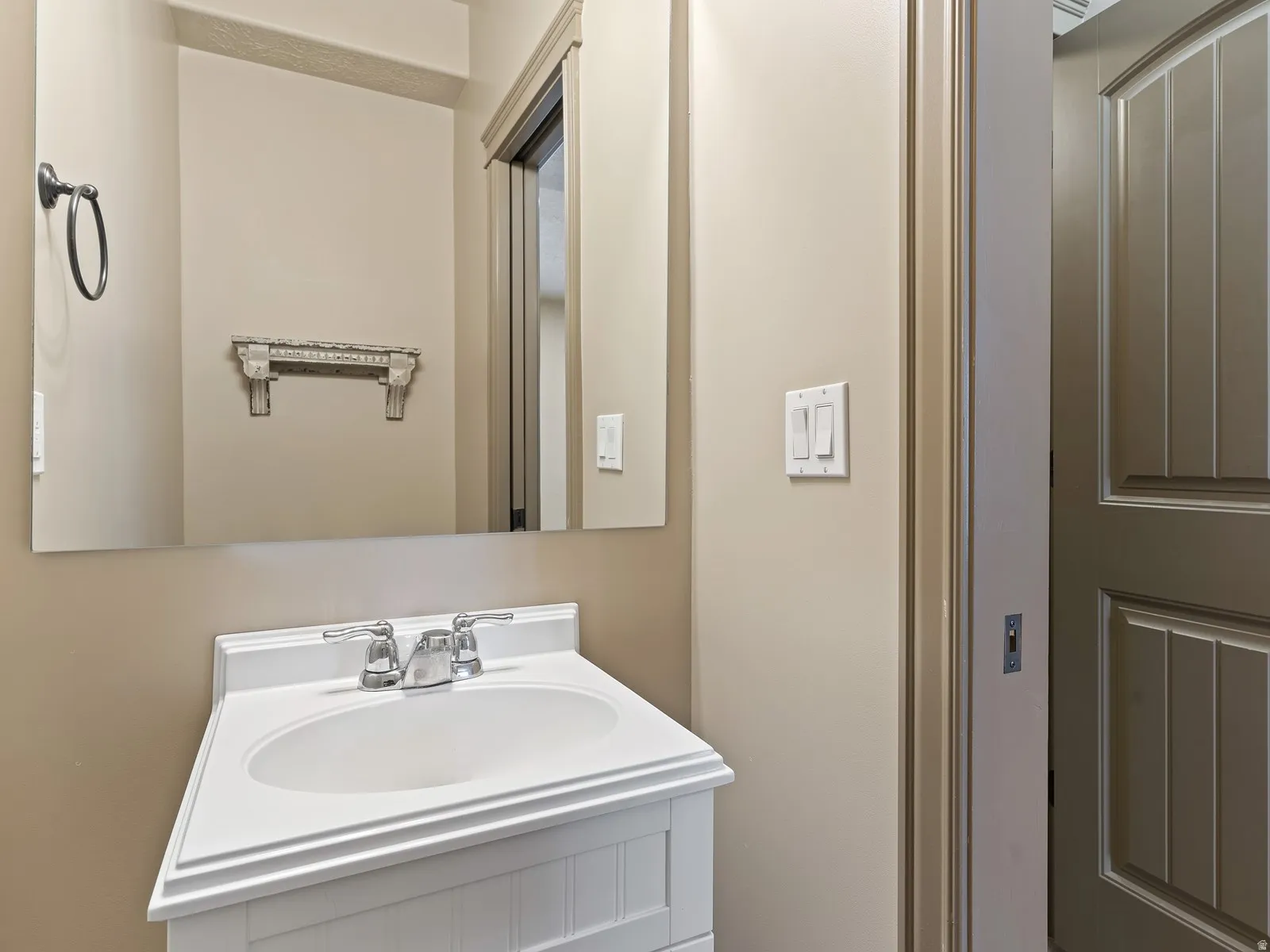 White vanity with integrated sink, chrome faucet, and rectangular mirror