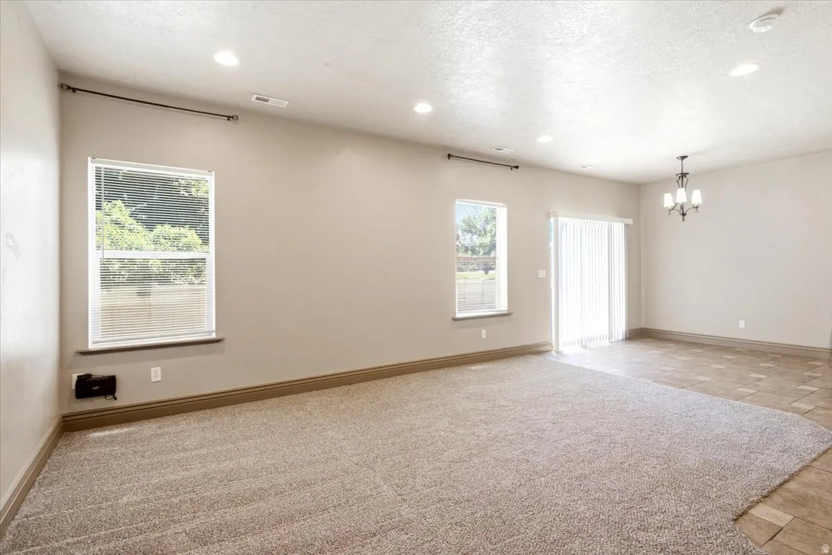 Spacious interior featuring neutral carpeting and a distinct tile area