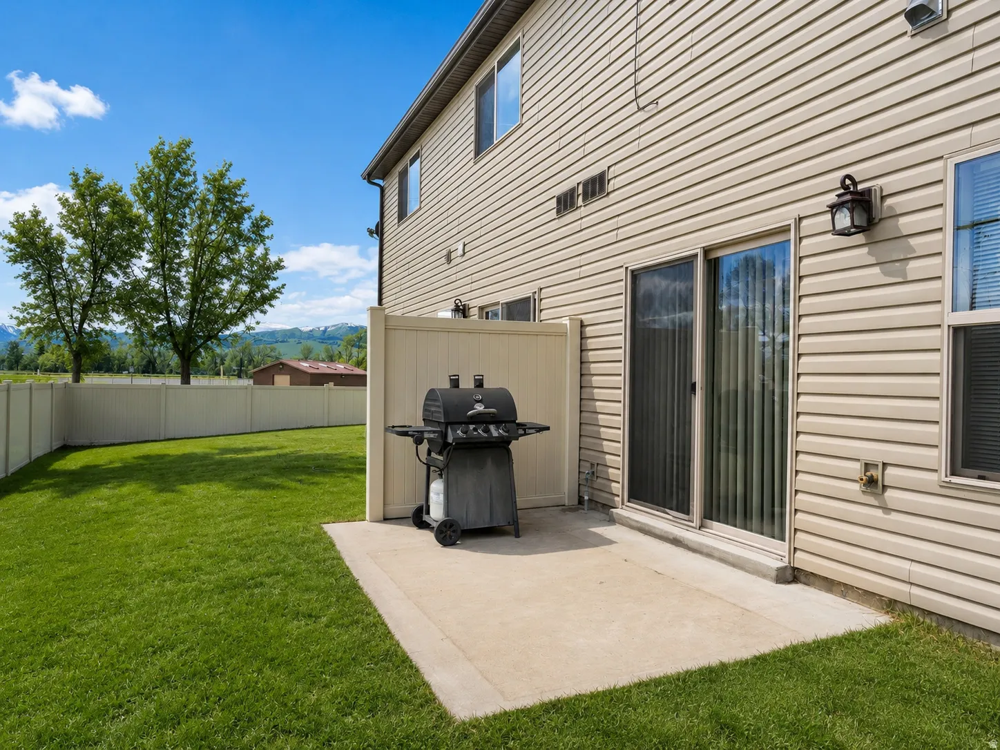 Expansive green lawn with a privacy fence