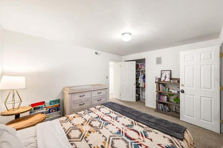 Spacious interior room with light-colored walls and textured carpet flooring
