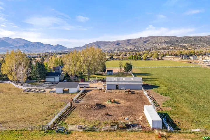 Expansive property featuring multiple outbuildings, fenced paddocks, and large open fields