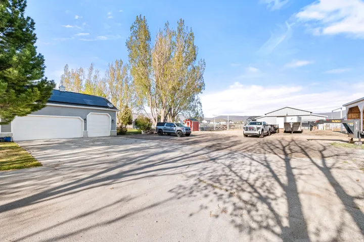 Spacious paved driveway offering access to the two-car garage with white doors and a cupola roof feature