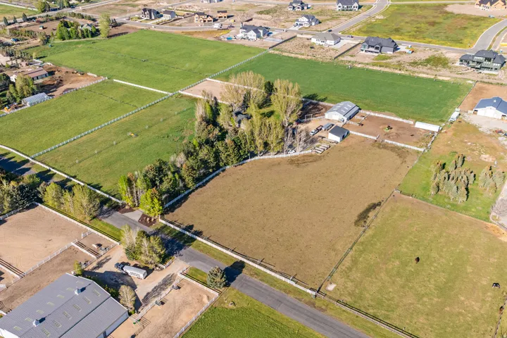 Expansive open fields with white perimeter fencing