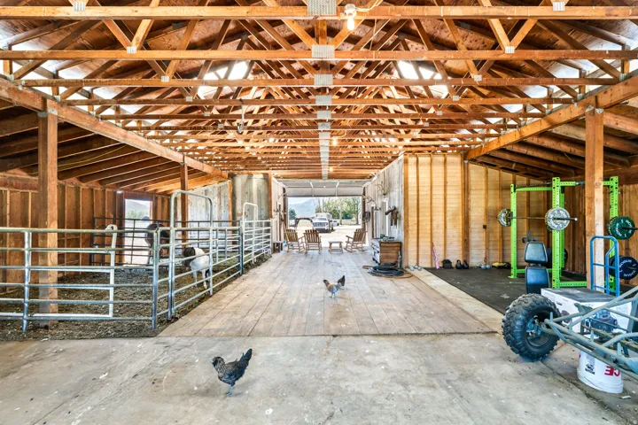 Spacious barn structure featuring exposed wooden trusses and framing