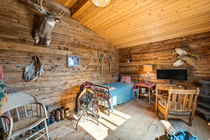 Wood-finish plank flooring and walls complementing a vaulted wood-finish plank ceiling