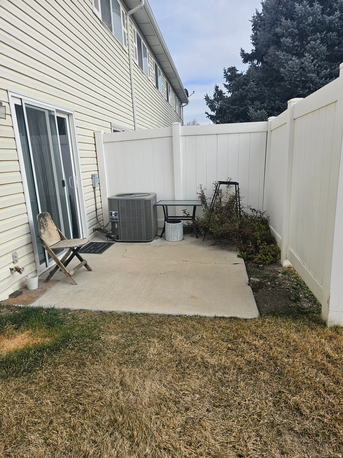 Private patio featuring a concrete surface, enclosed by a white vinyl fence