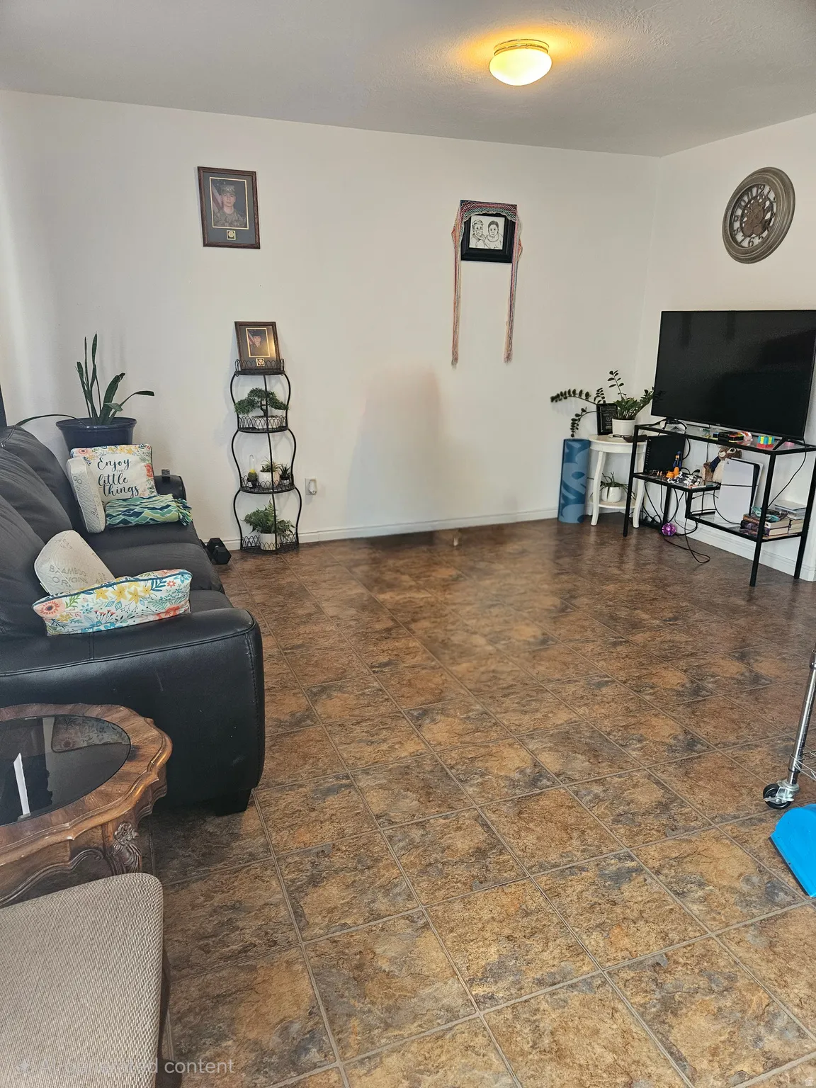 Spacious room featuring tile-finish flooring, white walls, and a ceiling-mounted light fixture