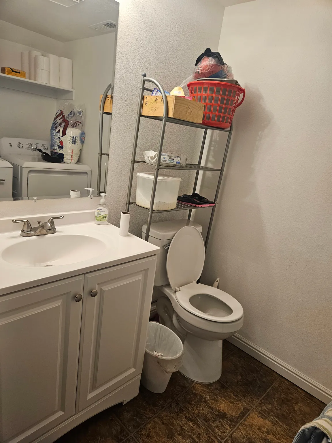 Bathroom with a single vanity, a mirror, and a toilet