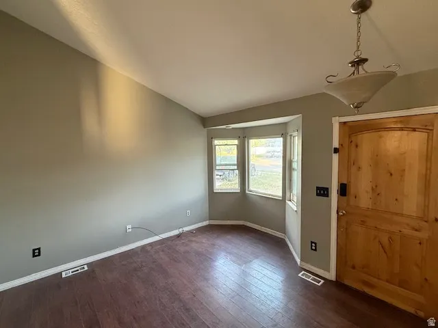 Entry area featuring wood-finish flooring, a natural wood door, and a bay window