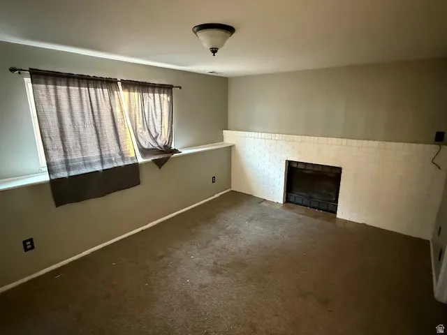 Room featuring a white brick fireplace with a black firebox