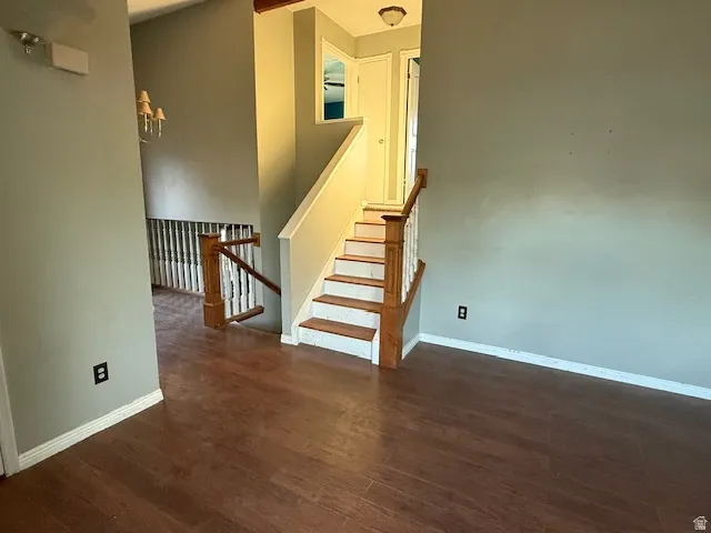 Staircase with wood-finish handrail and balusters, featuring white risers and wood-finish treads