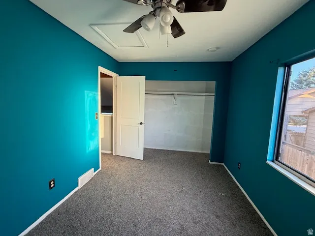 Room with teal painted walls and gray carpet flooring