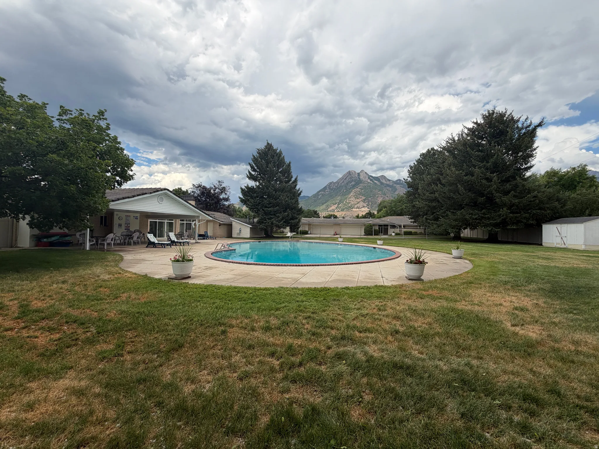 Club House Outdoor oasis featuring a large, oval-shaped swimming pool with a surrounding concrete patio