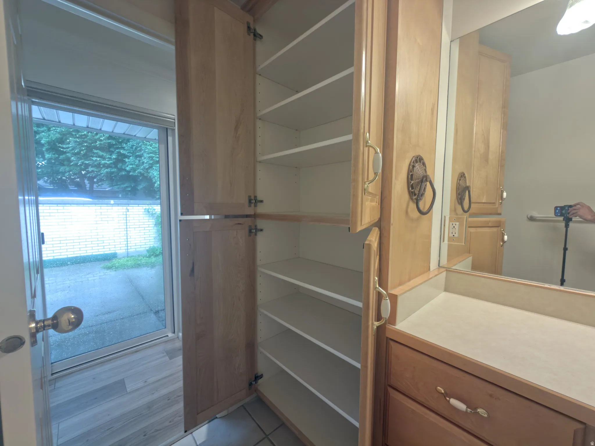 Integrated storage cabinetry featuring multiple shelves, a vanity area with a mirror, and wood-finish flooring