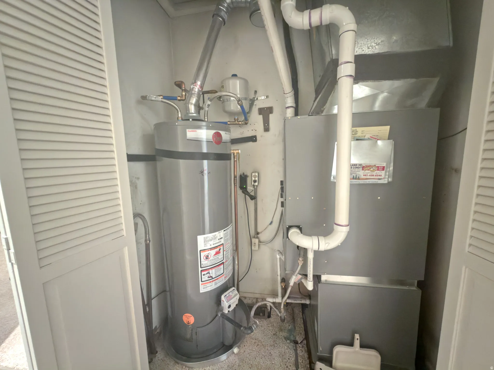 Utility closet featuring a water heater and HVAC system