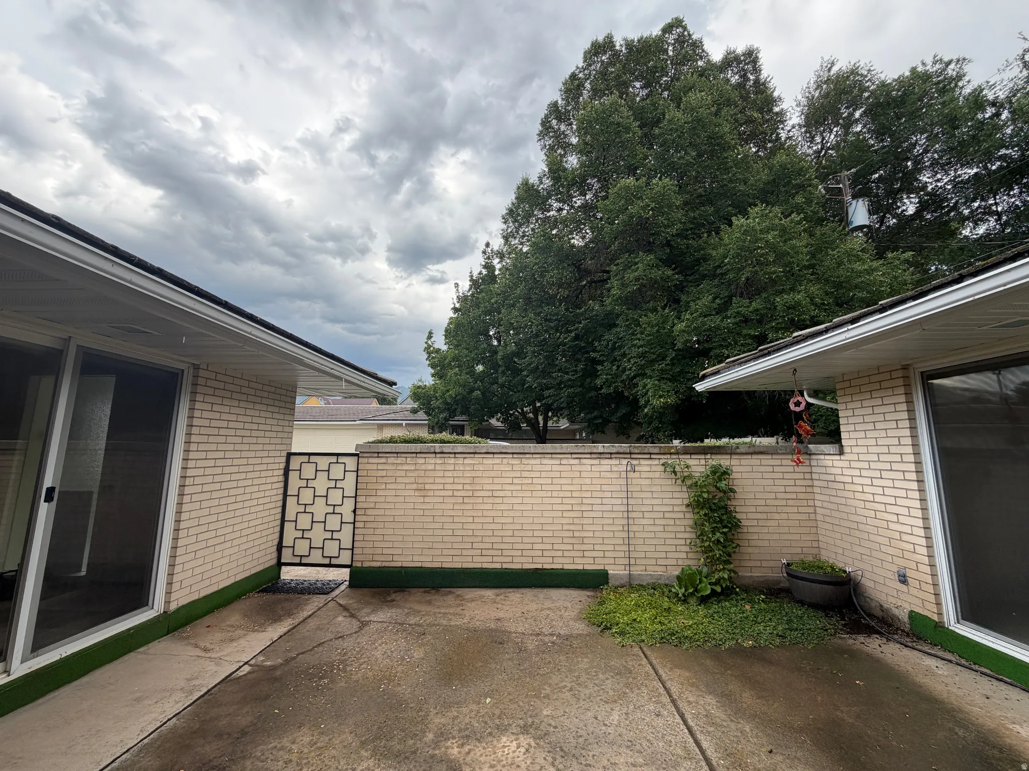Private patio space featuring concrete surfacing and a decorative metal gate