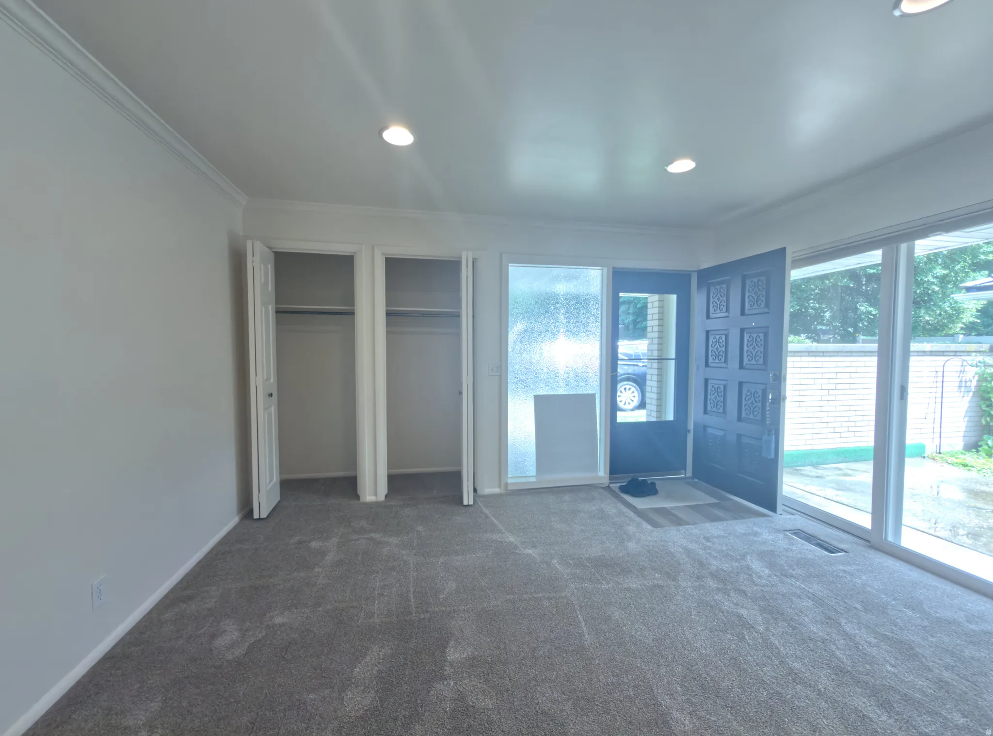 Entry area featuring a paneled front door, an adjacent frosted glass sidelight, and expansive sliding glass doors