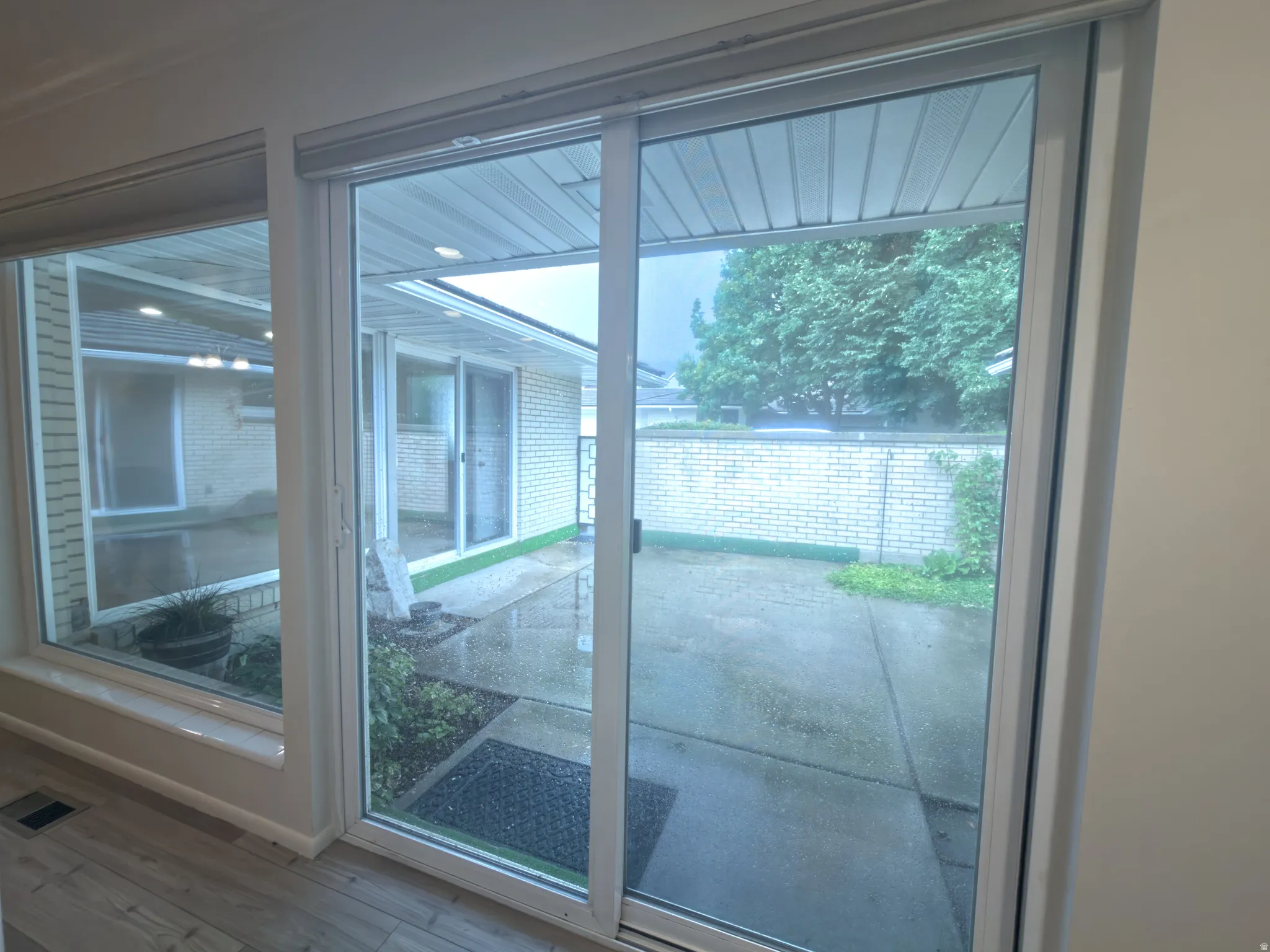Sliding glass door with white frame opening to a concrete patio