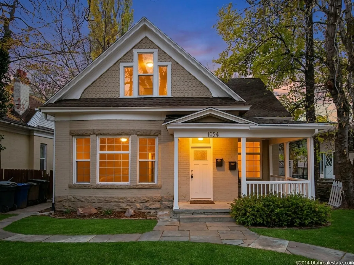 Traditional-style property featuring a covered porch, white railing, and a stone-paver walkway