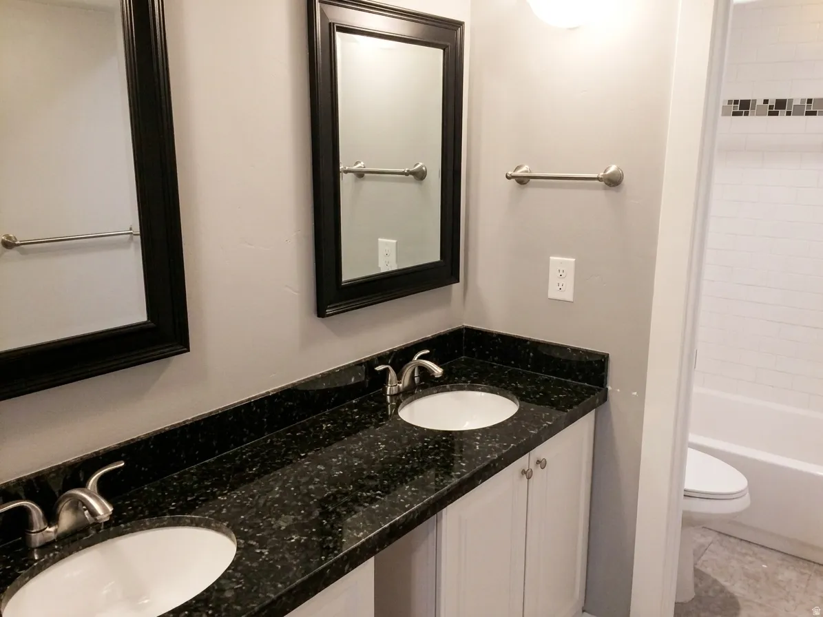 Double vanity with black speckled countertop and undermount sinks