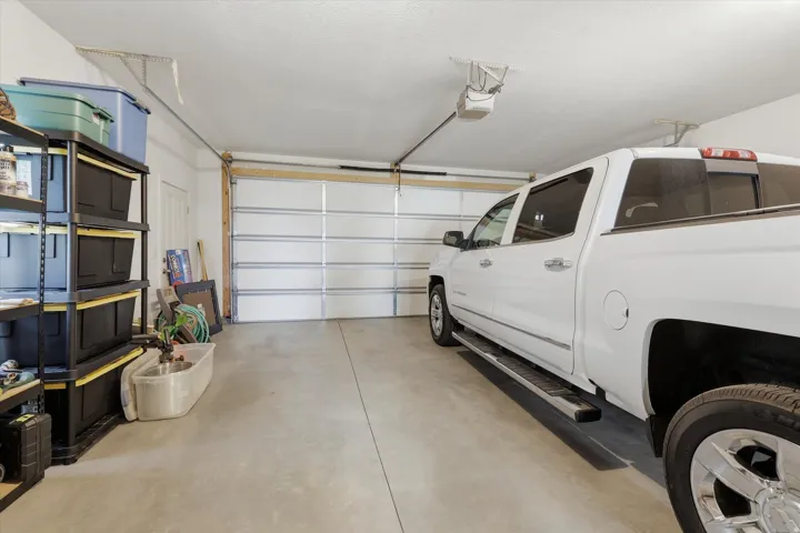 Spacious garage with a concrete floor and an automatic opener
