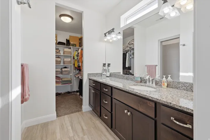 Master Bathroom granite countertop, and dark wood cabinetry