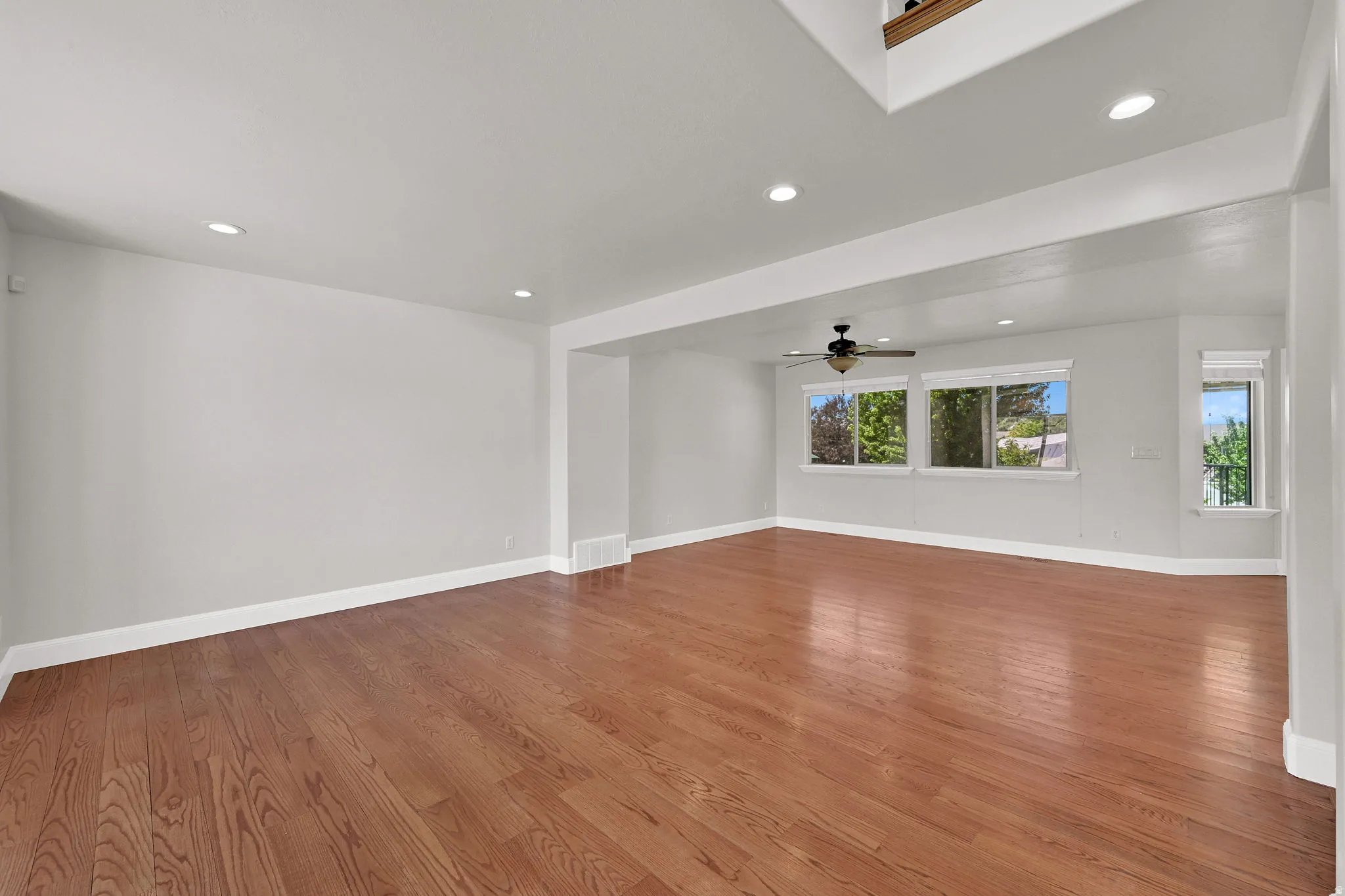 Expansive interior space featuring wood-finish flooring, recessed lighting, and multiple windows