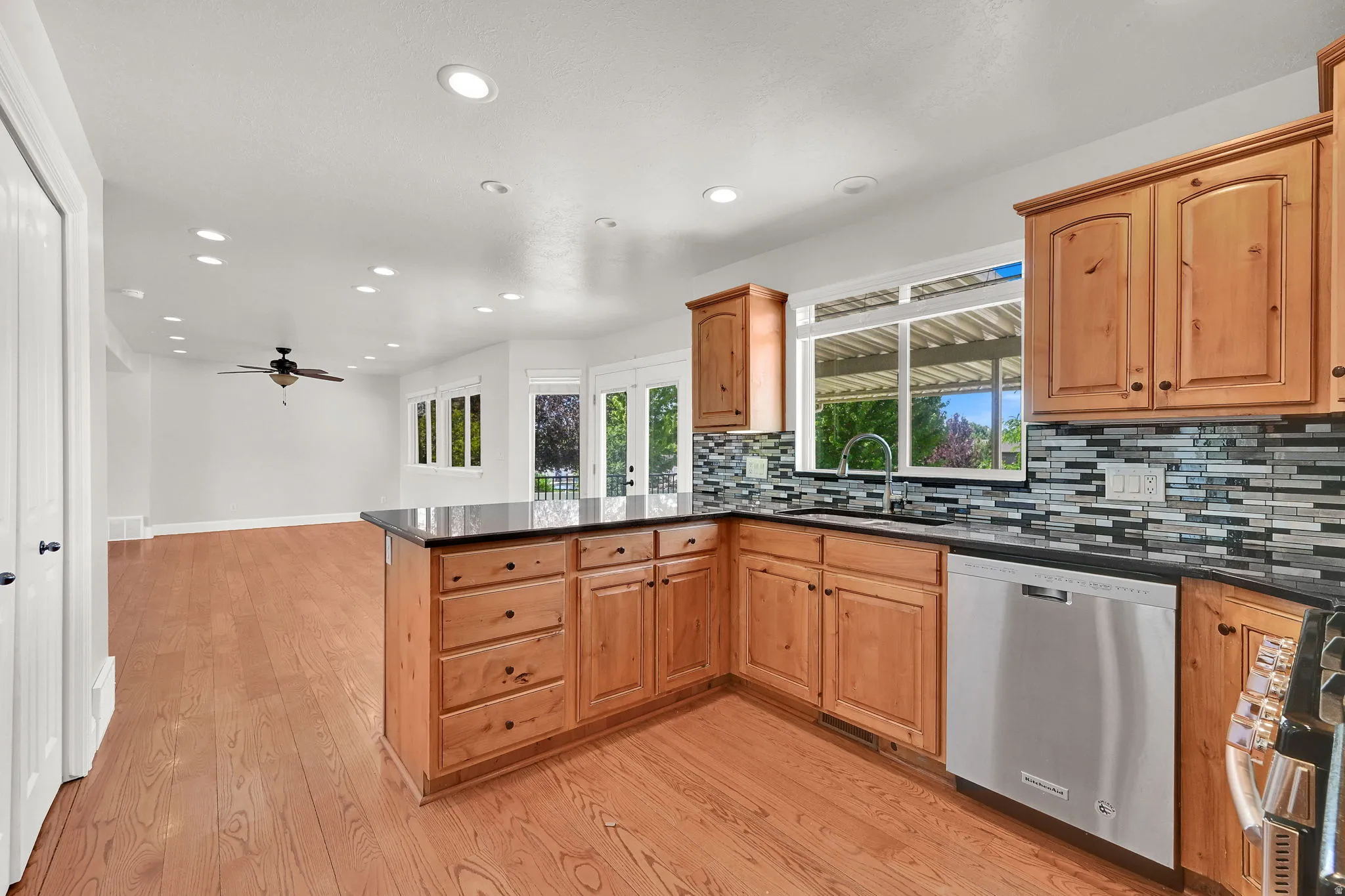 Kitchen featuring wood cabinetry, dark countertops, and a mosaic tile backsplash