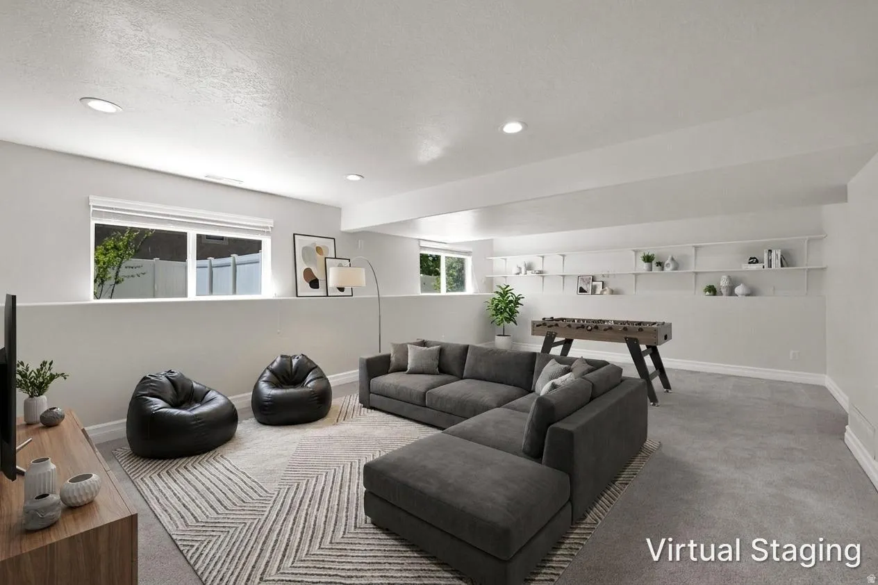 Spacious lower-level room featuring recessed lighting, multiple windows, and extensive built-in shelving