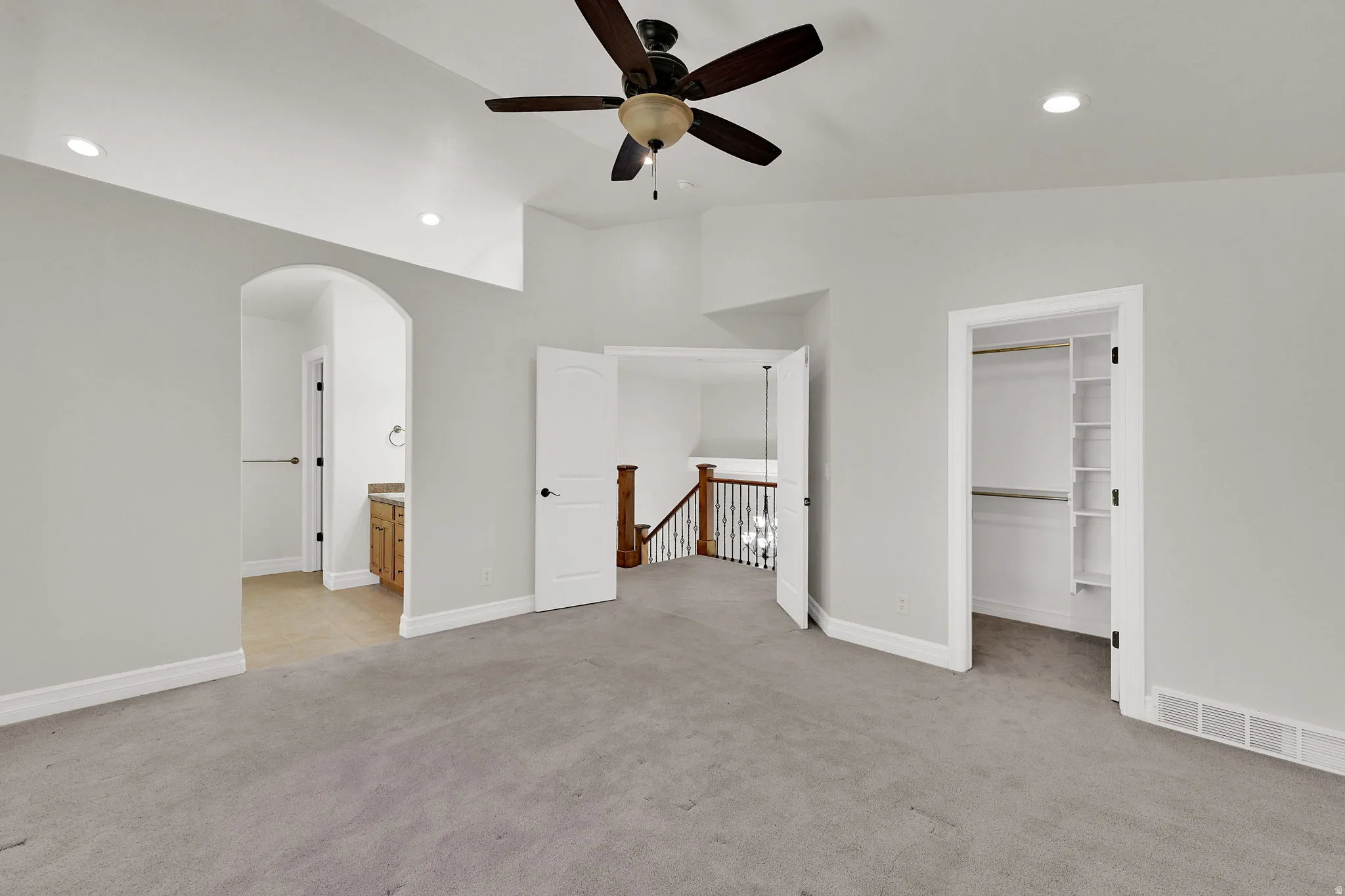 Carpeted room with a vaulted ceiling, recessed lighting, and a ceiling fan