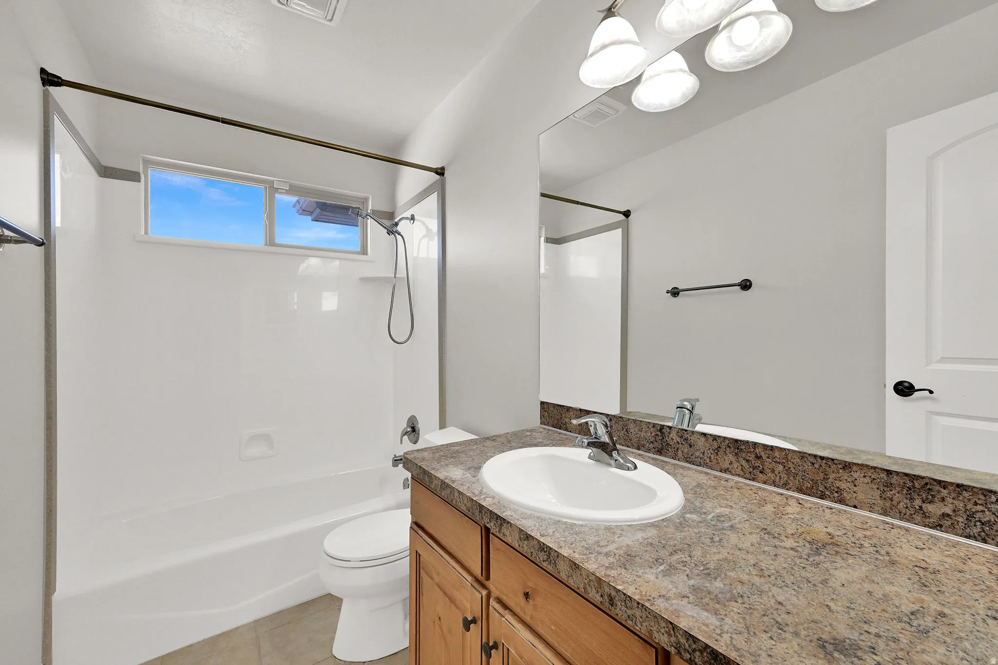 Bathroom featuring a single vanity with a laminate countertop and an integrated sink, illuminated by an overhead light fixture