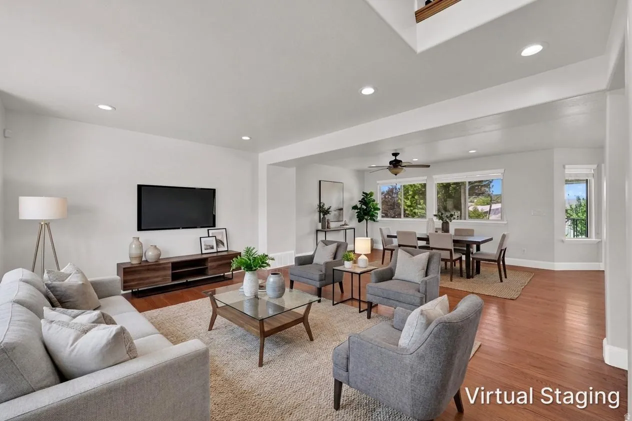 Open-concept living area featuring wood-finish flooring, recessed lighting, and white walls