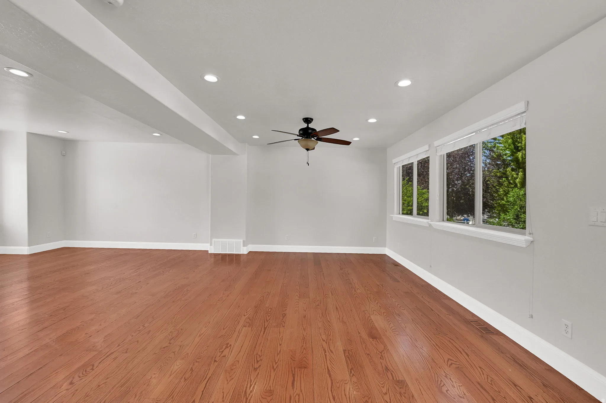 Spacious interior featuring wood-finish flooring, recessed lighting, and a ceiling fan