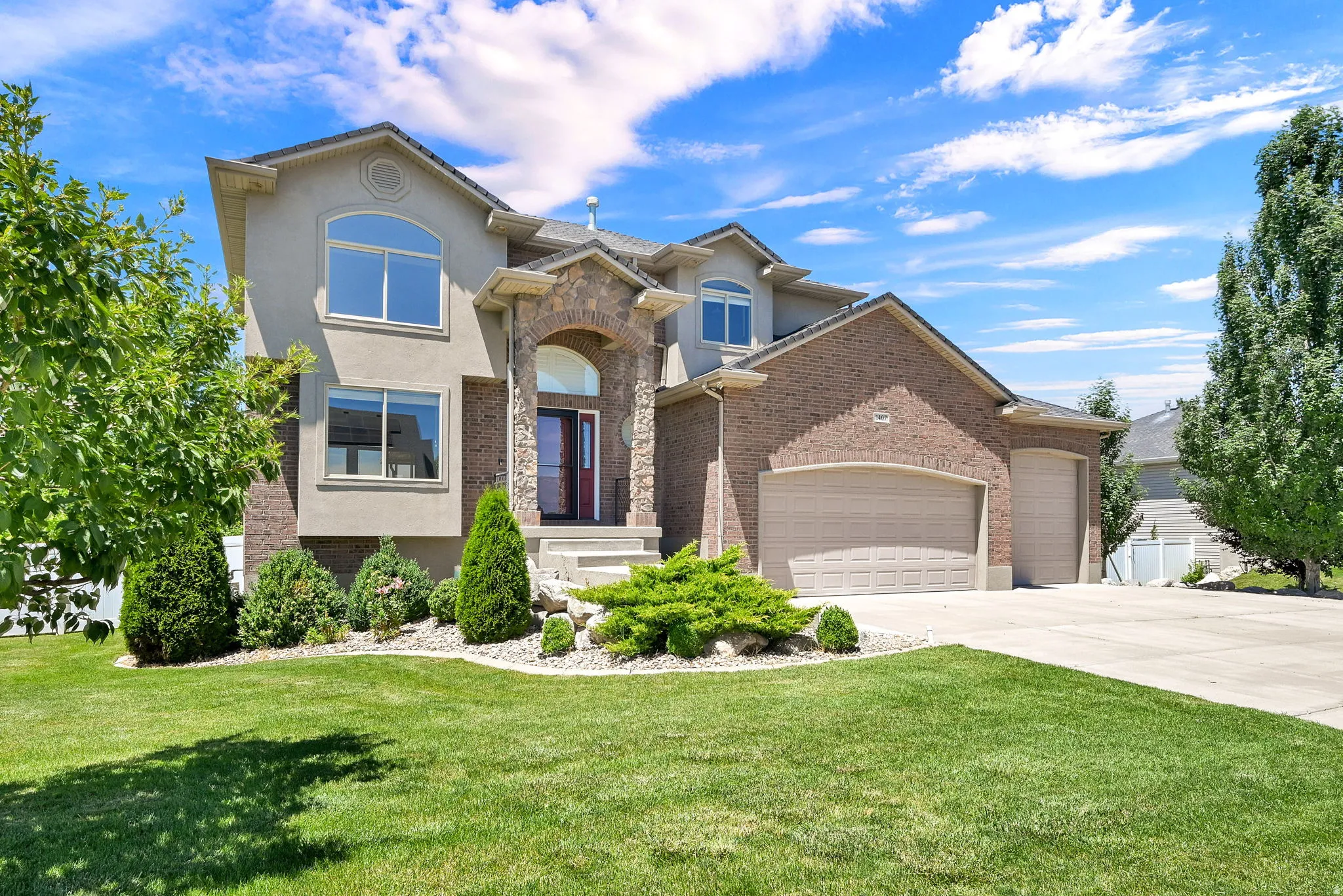 Stucco and brick exterior with arched entryway and multiple windows