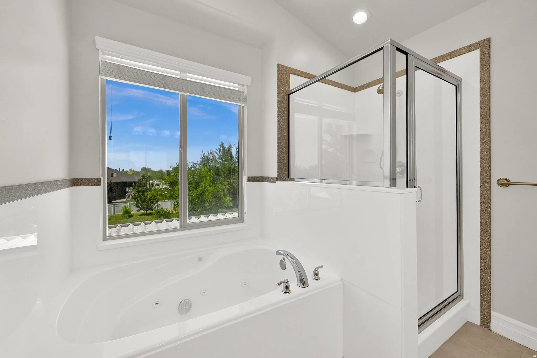 Soaking tub with integrated jets, chrome fixtures, and a large window
