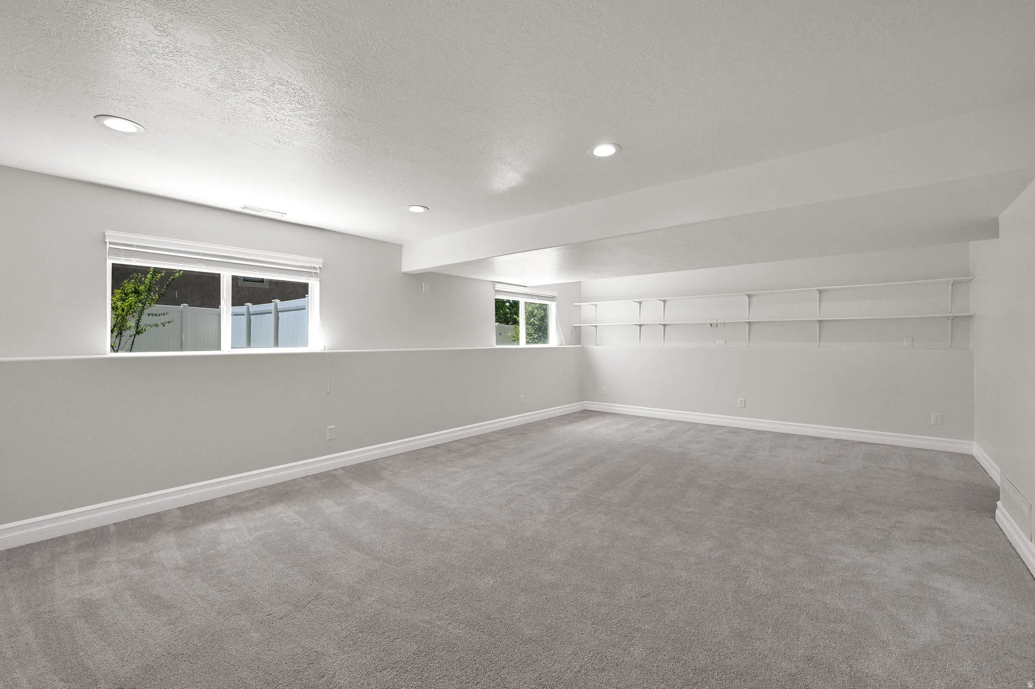 Spacious room featuring neutral carpeting and light gray walls