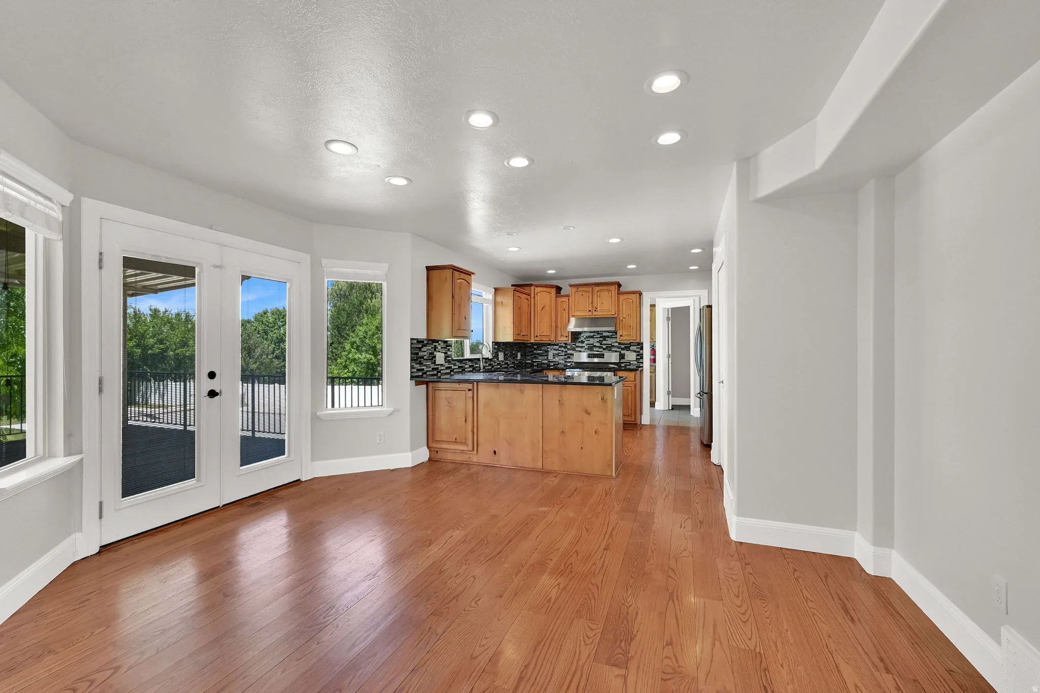 Hardwood-style flooring throughout the main living area, featuring light gray wall paint and recessed lighting