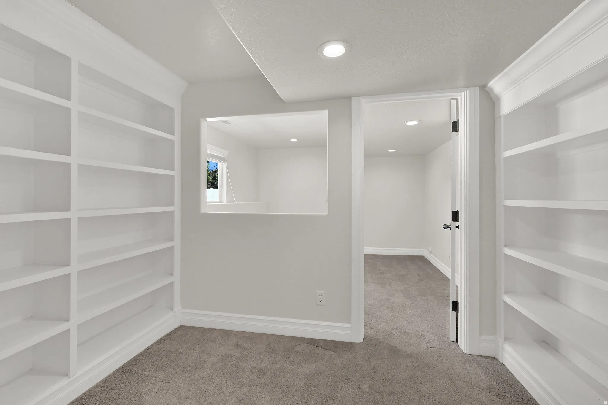 Bedroom featuring extensive built-in shelving, recessed lighting, and a neutral carpeted floor