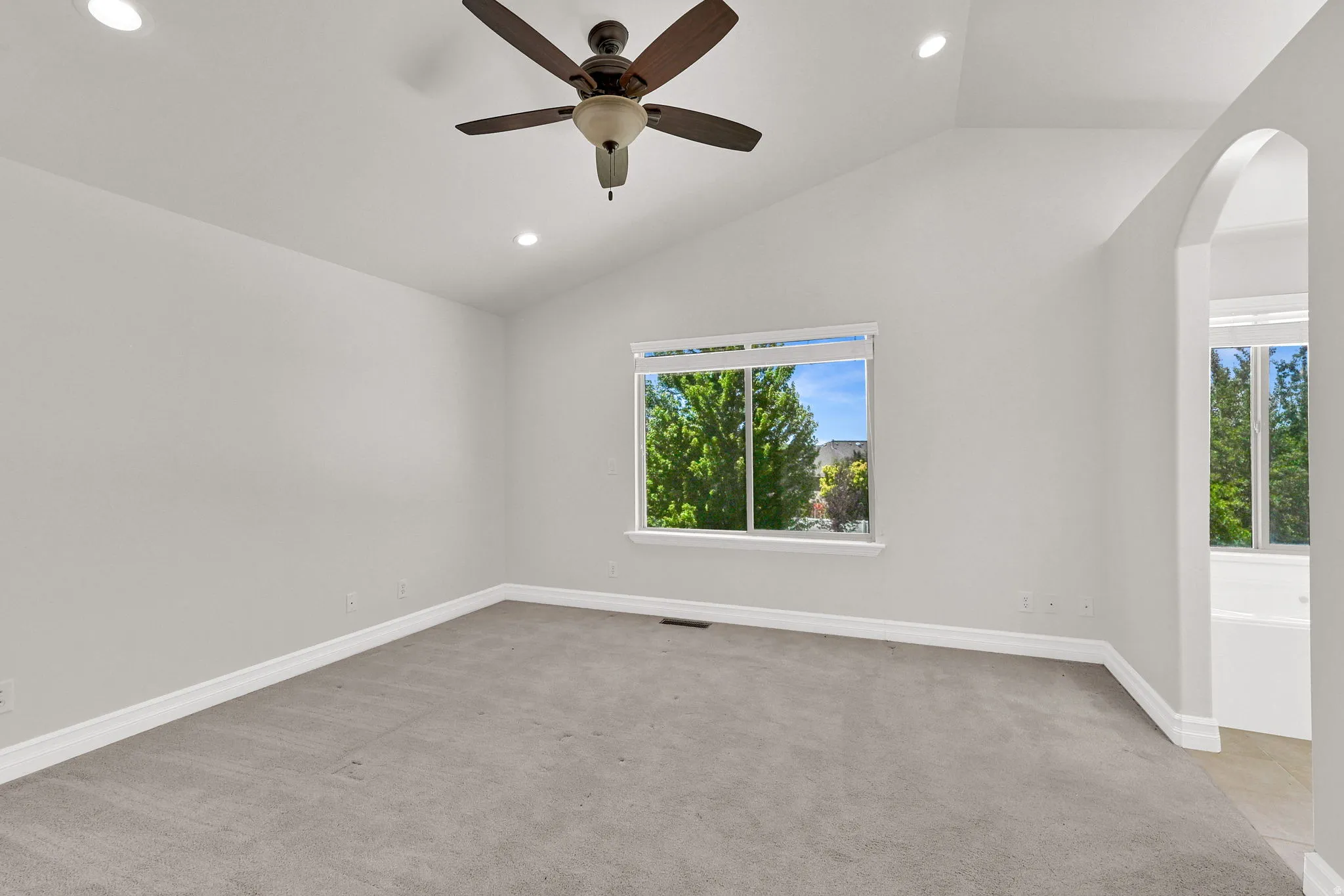 Spacious room with vaulted ceilings and recessed lighting