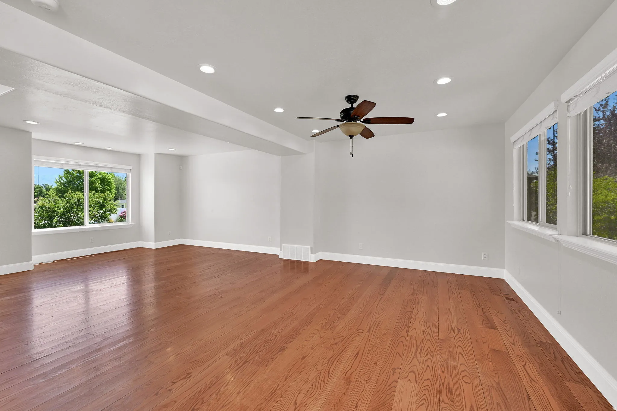 Spacious interior featuring wood-finish flooring, recessed lighting, and multiple windows