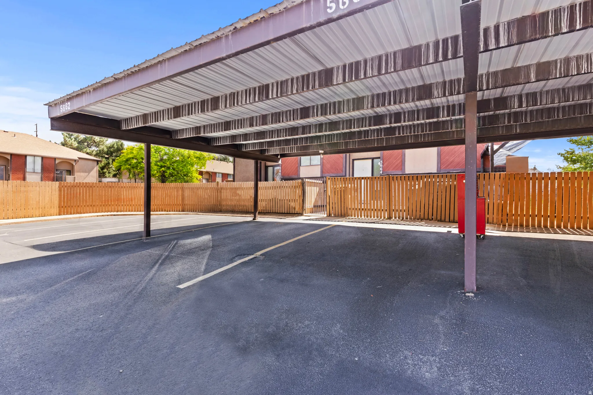 Covered parking structure featuring a metal roof and asphalt surface