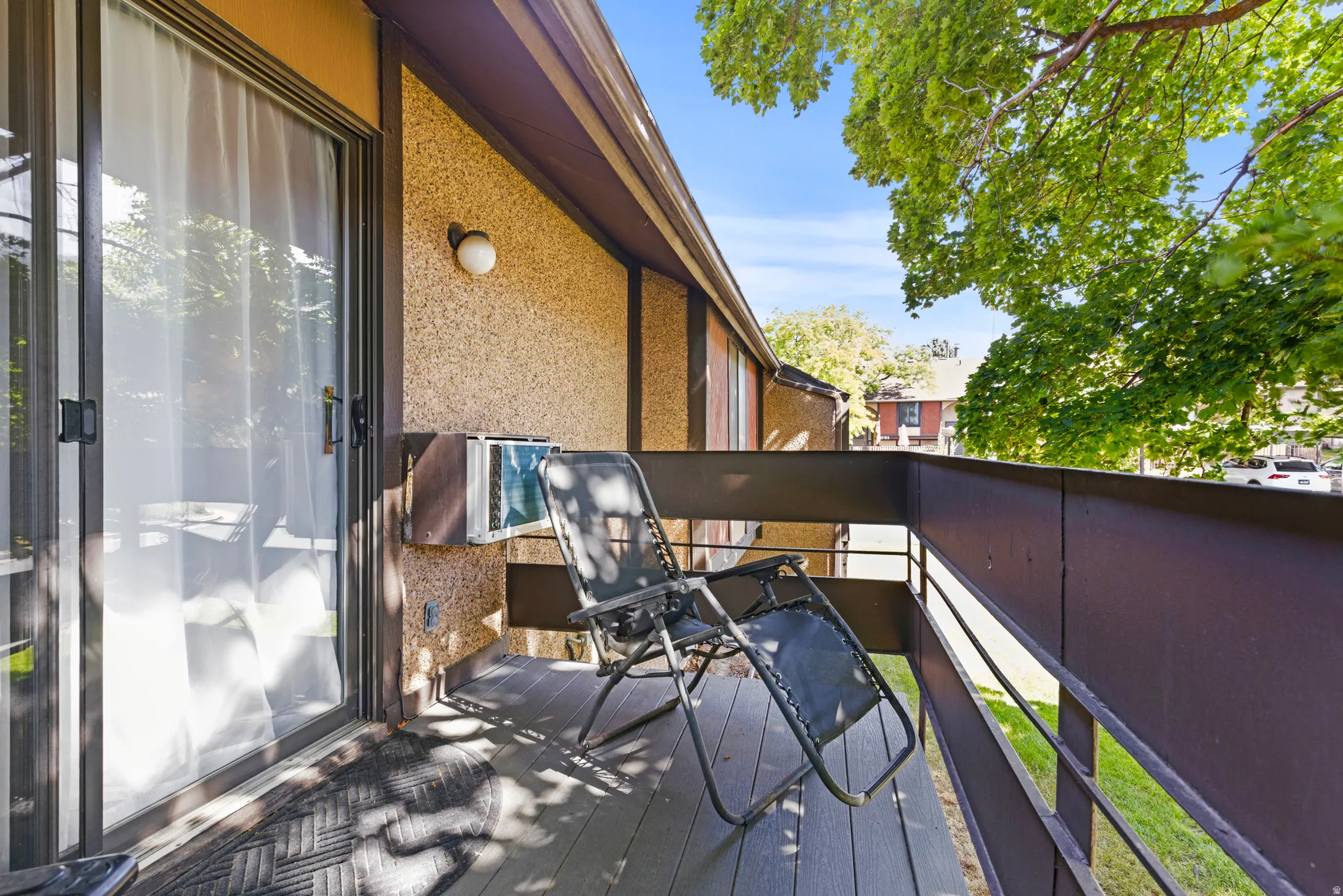 Private outdoor balcony featuring a wood-finish floor and dark-toned railing