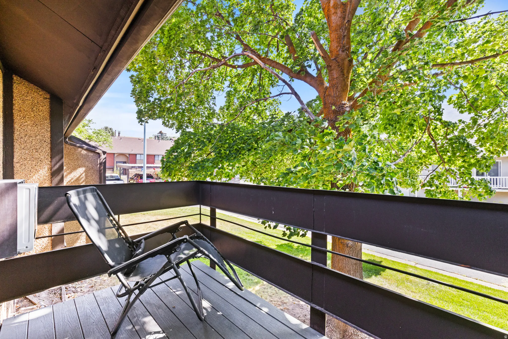Private balcony with wood-finish flooring and a metal railing