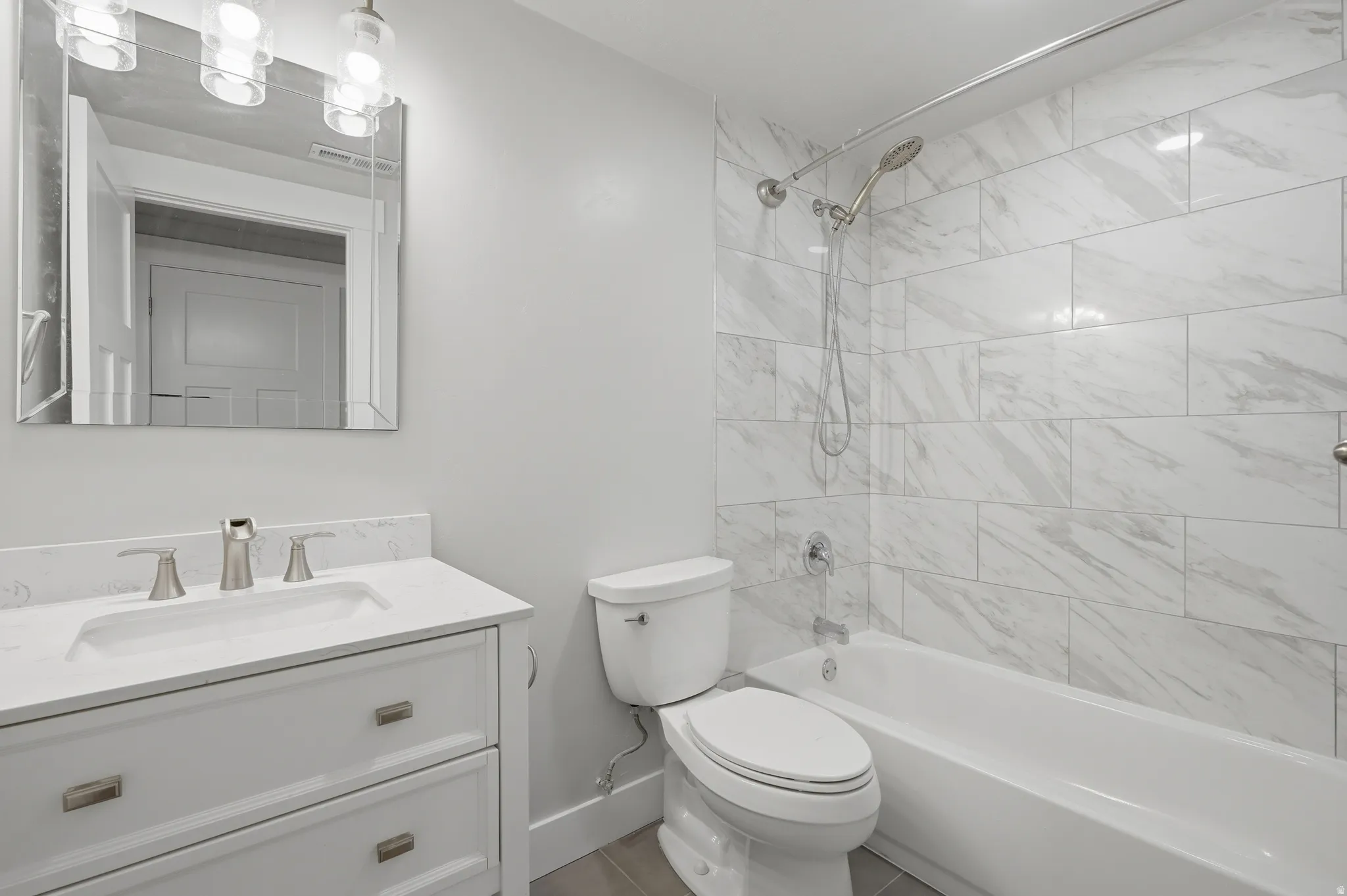 Bathroom featuring a white vanity with a rectangular sink, a white countertop, and brushed nickel fixtures