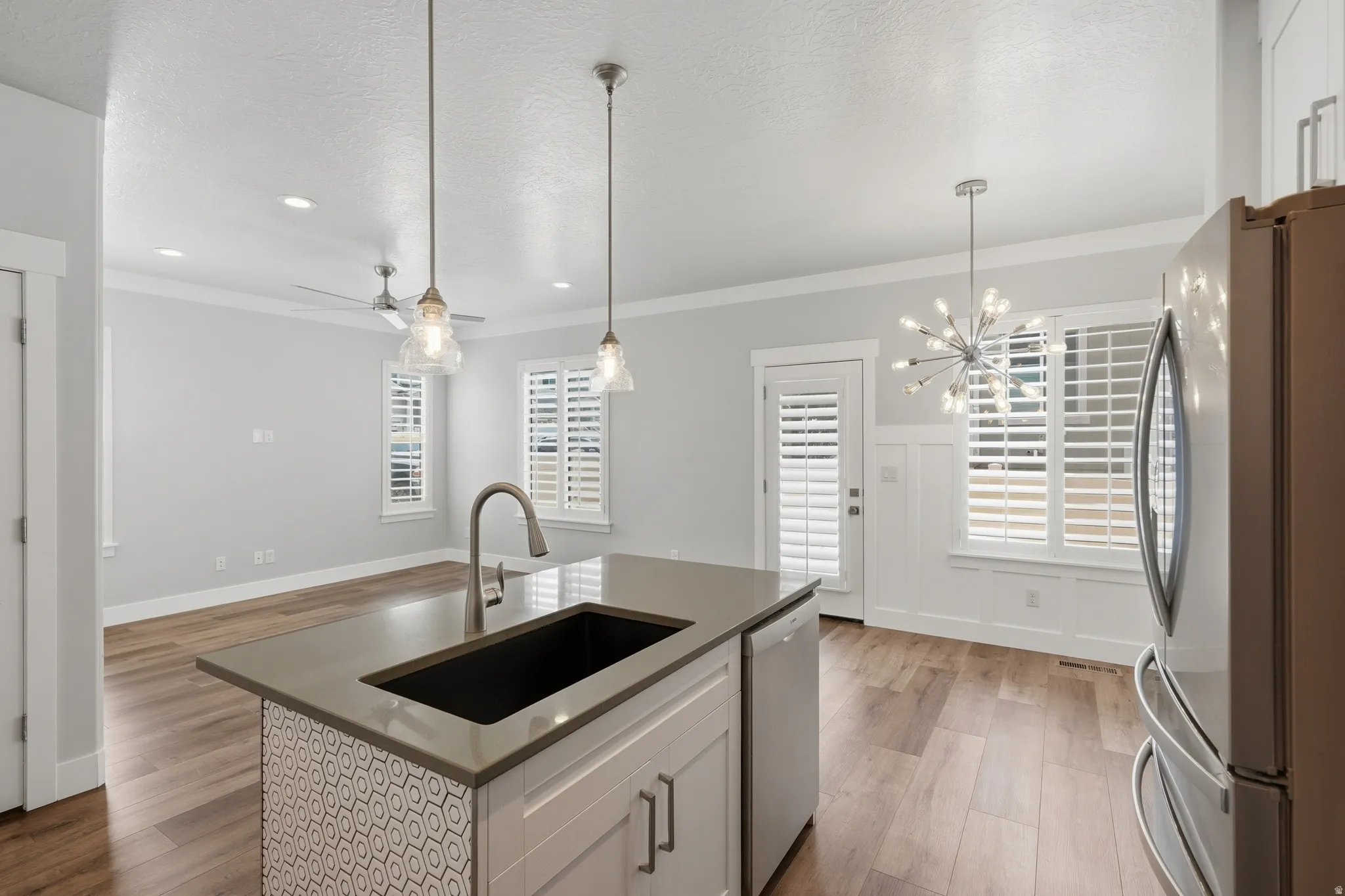 Kitchen island with an undermount sink, a gooseneck faucet, and pendant lighting